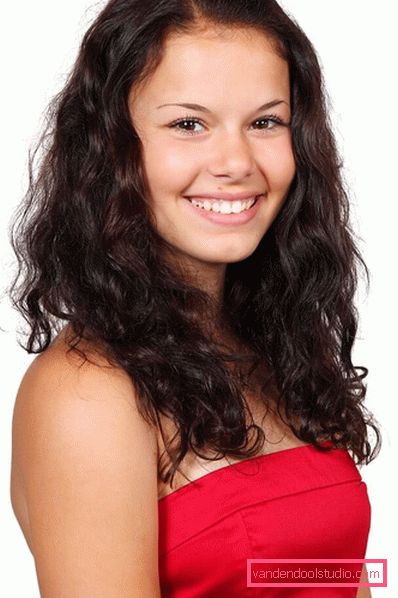 bella ragazza sorridente con i capelli mossi ricci