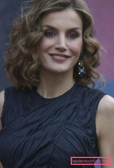 Stile elegante e alla moda su capelli medi con grandi ricci