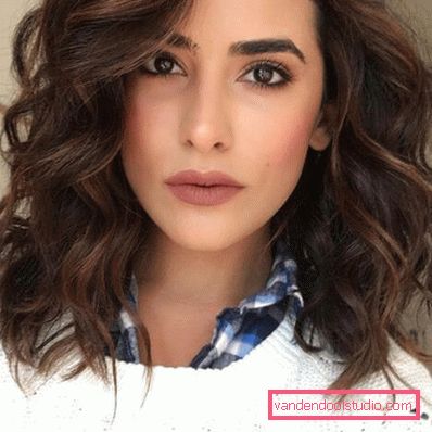 Stile elegante e alla moda su capelli medi con grandi ricci