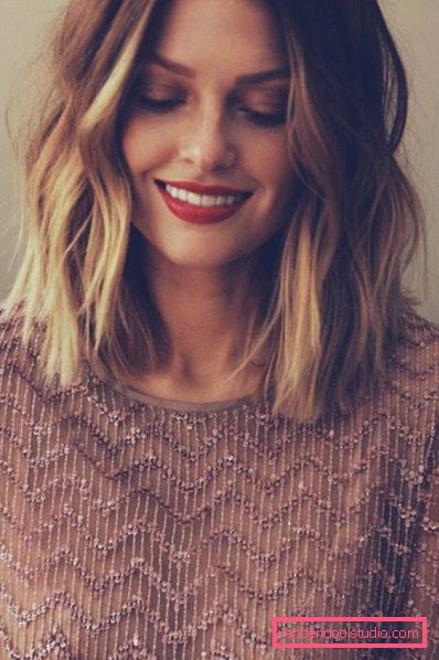 Shatush su capelli biondi ricci di media lunghezza