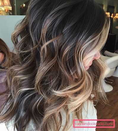 Shatush ha un aspetto magnifico su capelli scuri ricci di media lunghezza