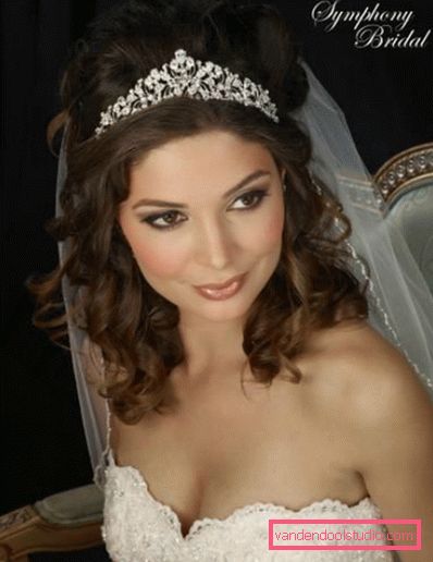 Acconciature da sposa con riccioli fluenti su capelli medi con un velo